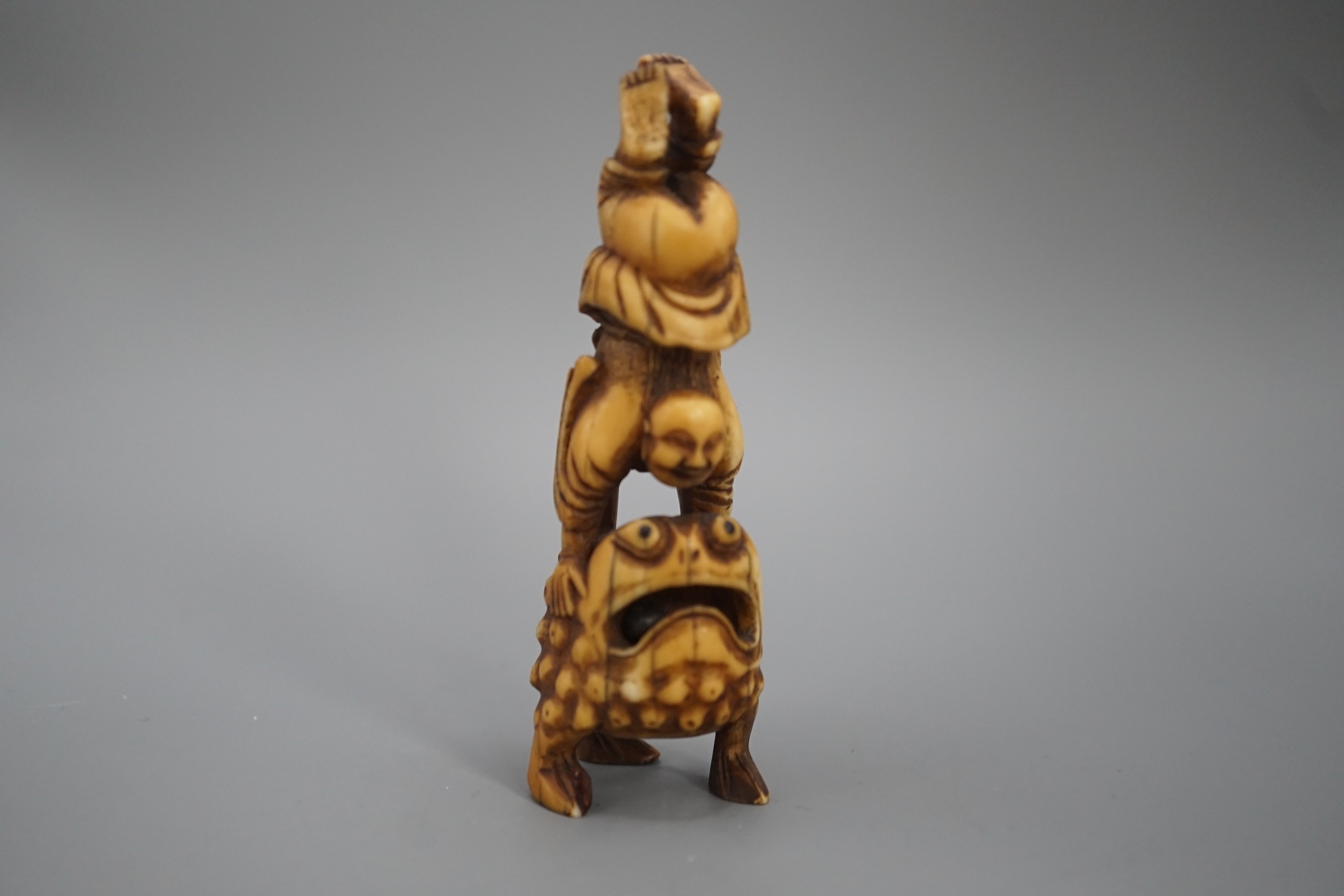 A 19th century Chinese or Japanese carved walrus ivory figure of Liu Hai balancing on his three legged toad, 9cm